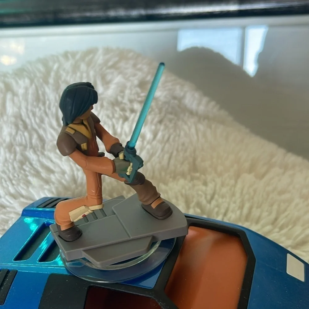 Action Figure with Blue Lightsaber on Vehicle
